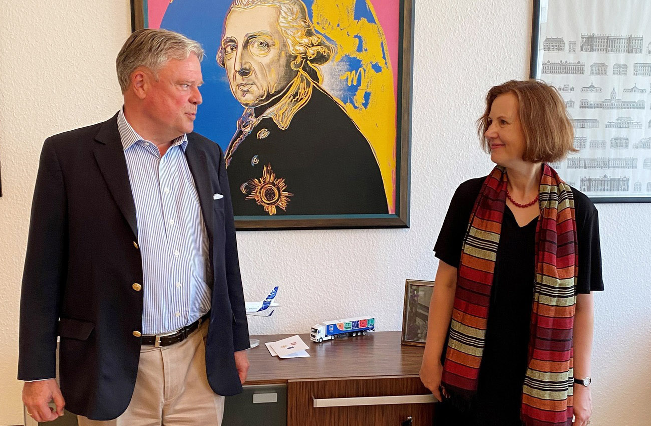 Botschafter Matthias Sonn zeigt Vera Schneider den Alten Fritz – in der Version von Andy Warhol. Foto: © Vokietijos ambasada Vilniuje/Deutsche Botschaft Wilna, 2022