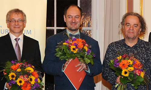 Die Georg Dehio-Buchpreisträger 2018 mit Blumen in der Hand von links: Alvydas Šlepikas, Markus Roduner und Miljenko Jergović. Brigitte Döbert fehlt krankheitsbedingt. Rechts daneben Dr. Günter Winands, BKM. Links außen Winfried Smaczny und ganz rechts Harald Roth vom Deutschen Kulturforum östliches Europa.