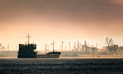 Ein Schiff fährt im Morgengrauen den Rigaer Hafen an. © InfinitumProdux/AdobeStock