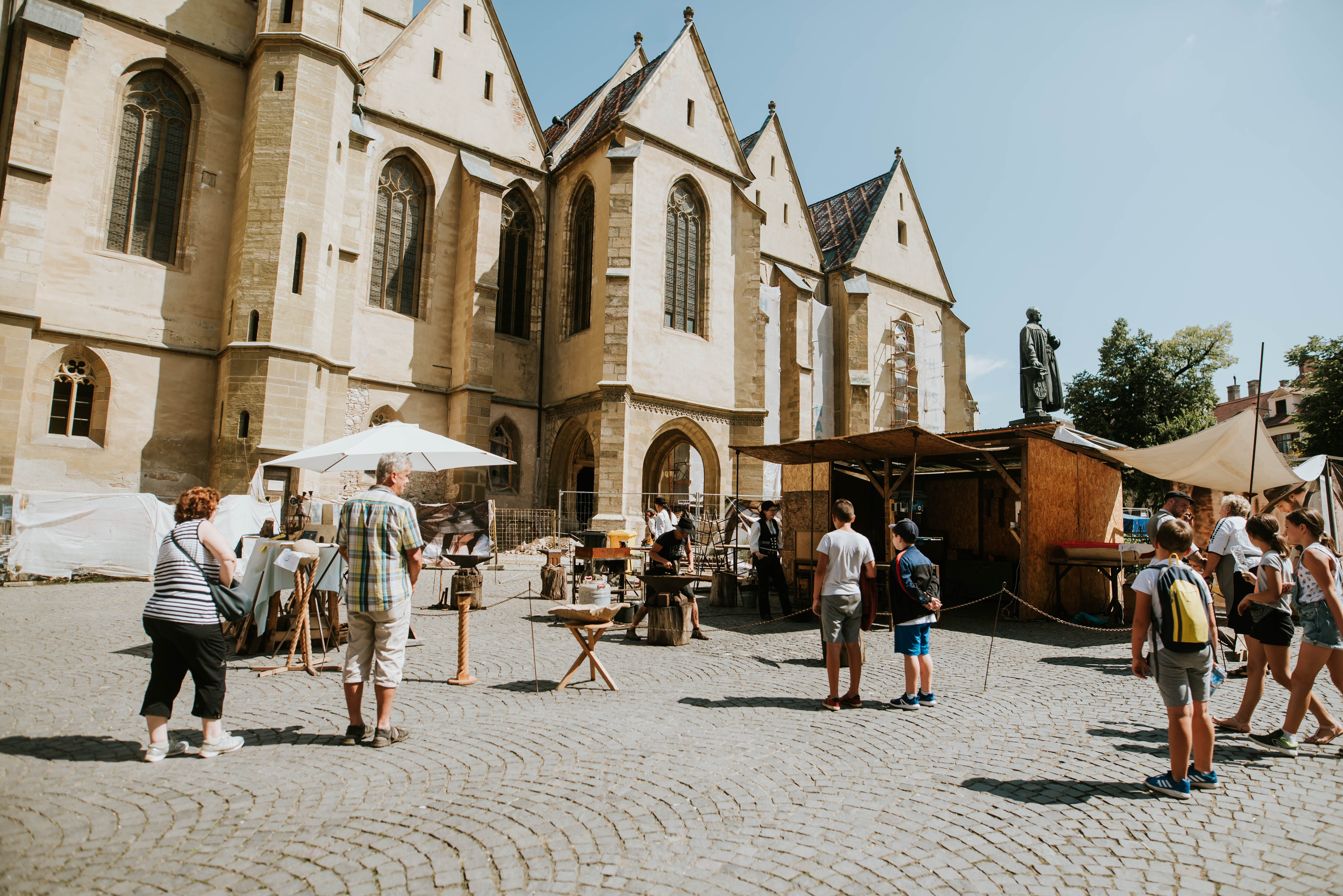 Die Wandergesellen nehmen Restaurierungsarbeiten an der evangelischen Stadtpfarrkirche vor, während Besucher sie beobachten.© Deutsche Gesellschaft e.V.