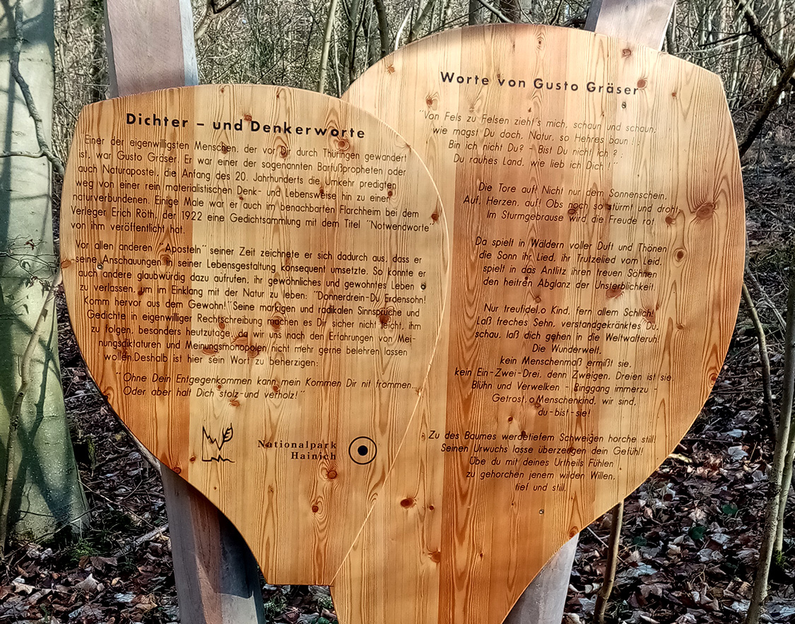 Als »Barfußprophet« wird Gusto Gräser auf diesem Schild im Nationalpark Hainich bezeichnet und einige Verse eines seiner Gedichte zitiert. Zu Lebzeiten ist Gräser selbst im Thüringer Wald gewandert. Foto: © Jwoll-bold/Wikicommons