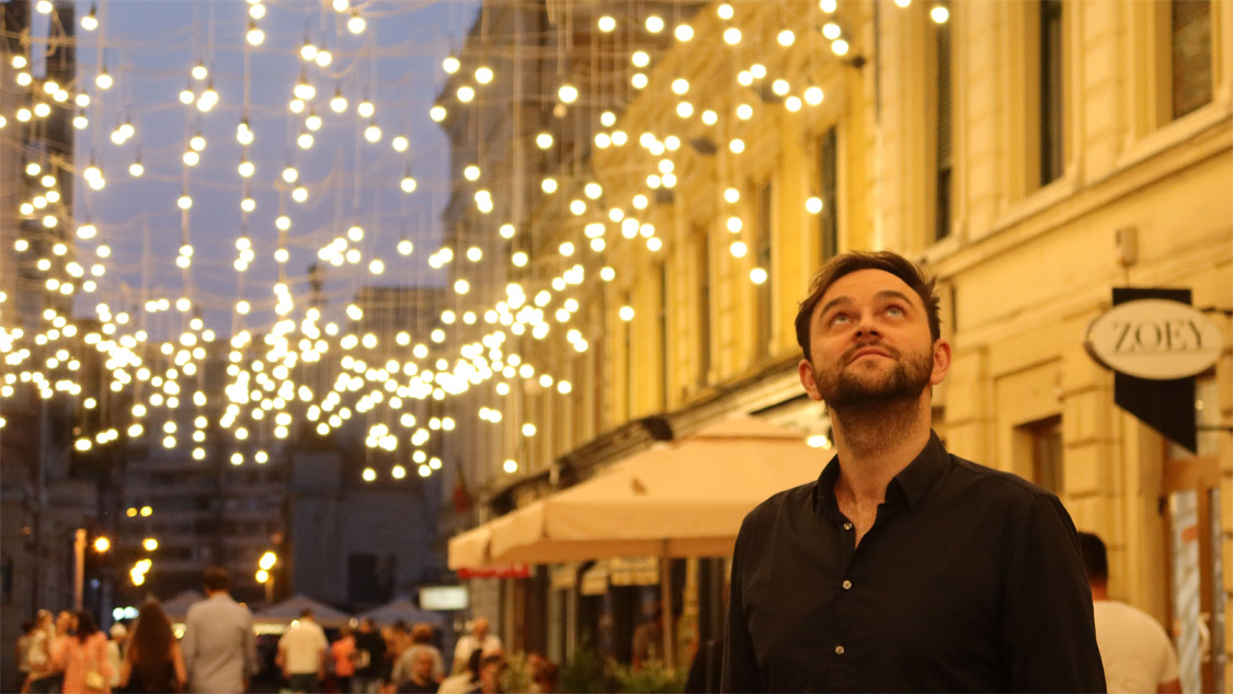 Thomas Perle bewundert die Lichter auf der Strada Pietonală Vasile Alecsandri. © Deutsches Kulturforum östliches Europa, 2023 • Vera Schneider