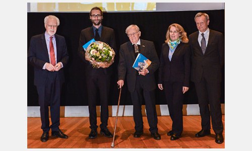 Paul Philippi (uprostřed) a Jaroslav Ostrčilík (druhý zleva) na jevišti při udílení. Ceny předala Maria Bering, náměstkyně Pověřeňkyně spolkové vlády pro kulturu a média. Vlevo předseda představentsva DKF Winfried Smaczny a vpravo ředitel Harald Roth. 