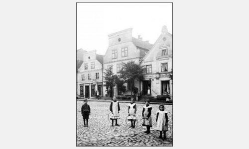 Die Reifenmädchen. Auf dem Markt in Mohrungen. Dziewczynki z kółkami. Na rynku w Morągu. um/ok. 1910